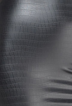 Close-up of black crocodile-pattern wetlook fabric.